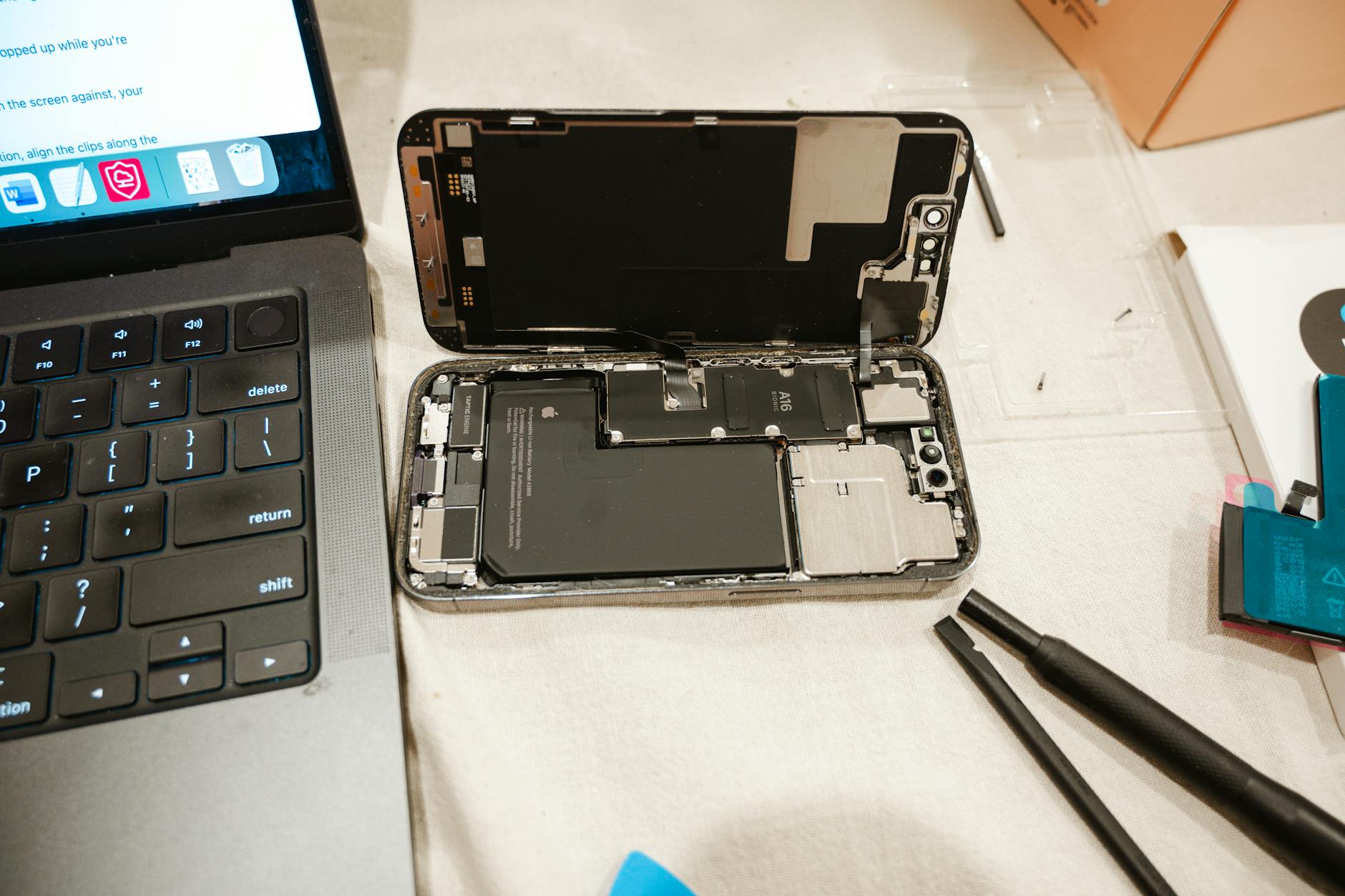 Otwarte wnętrze iPhone’a z narzędziami do samodzielnej wymiany baterii