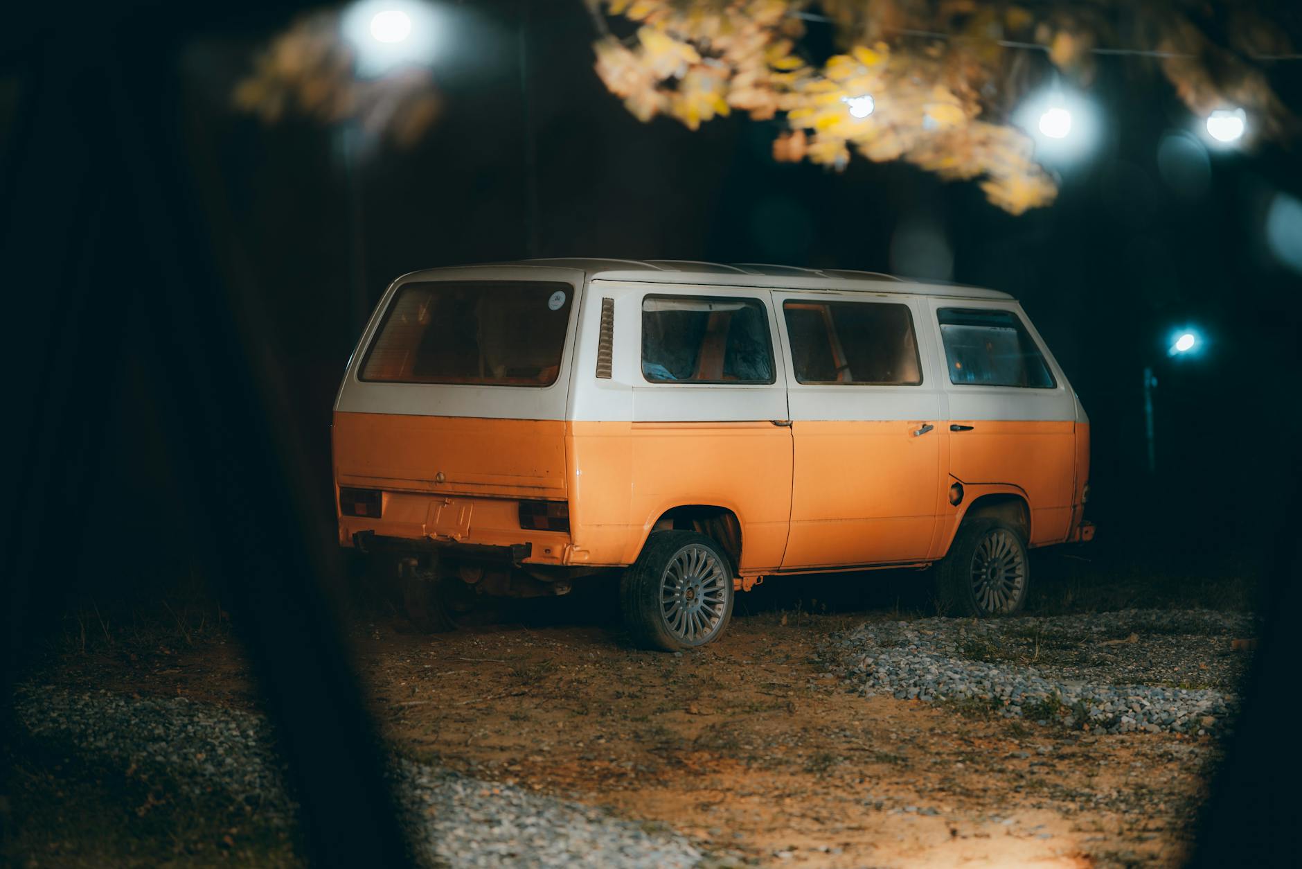 Retro kamper zaparkowany nocą pod lampami, nastrojowe oświetlenie