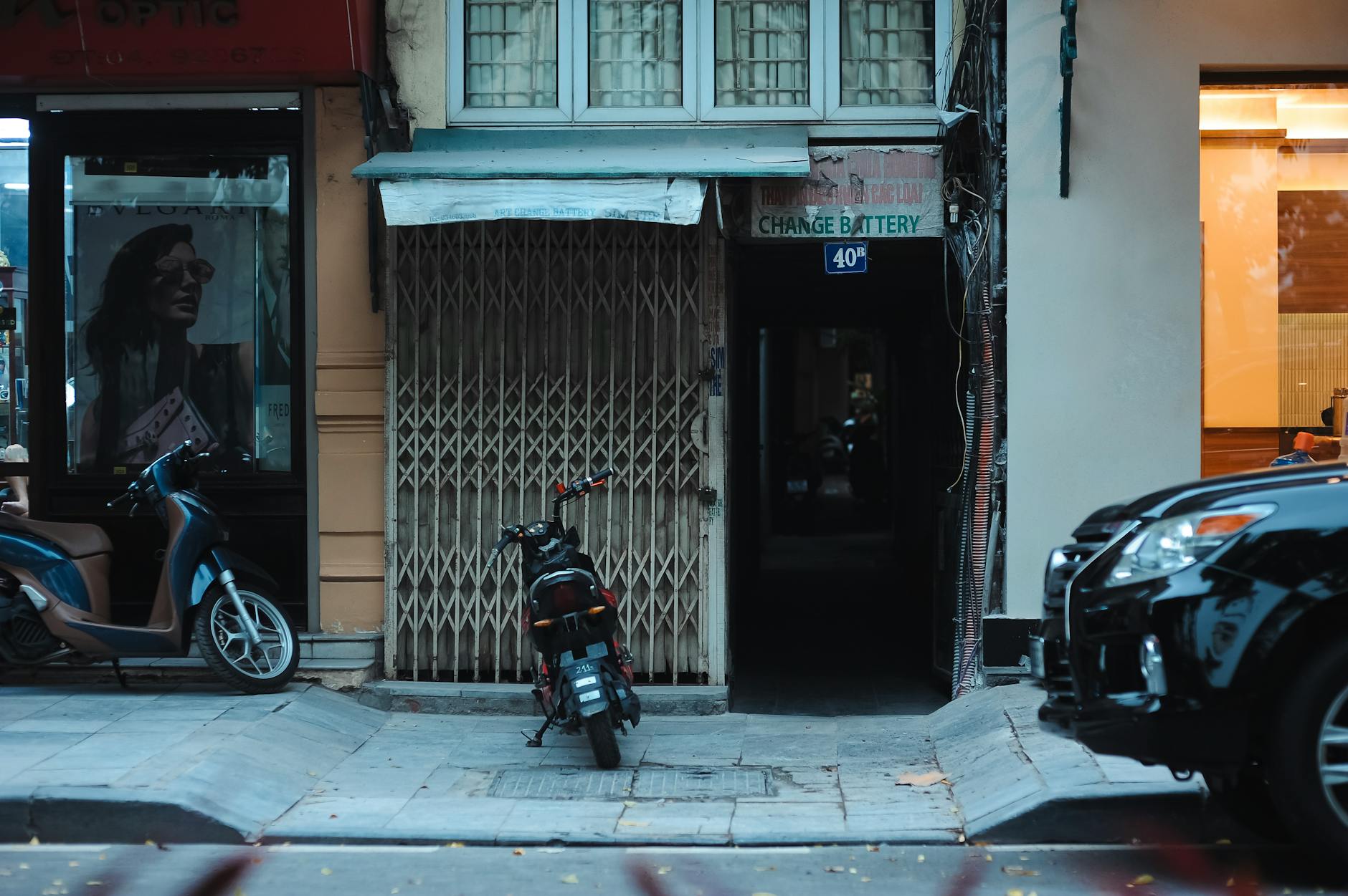 Skutery zaparkowane przy ulicy z szyldami sklepów w mieście