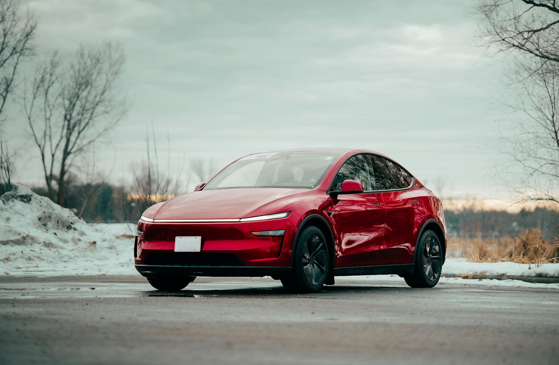 Czerwony samochód elektryczny zaparkowany zimą na zewnątrz