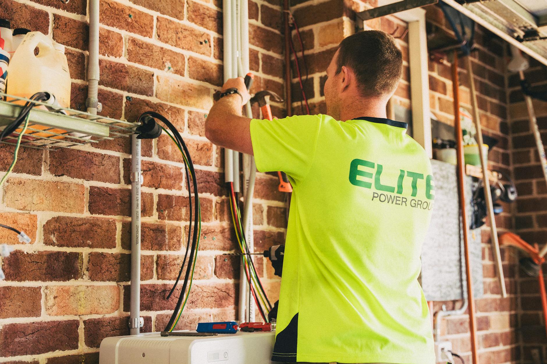Elektryk montuje akumulator w domowej instalacji elektrycznej