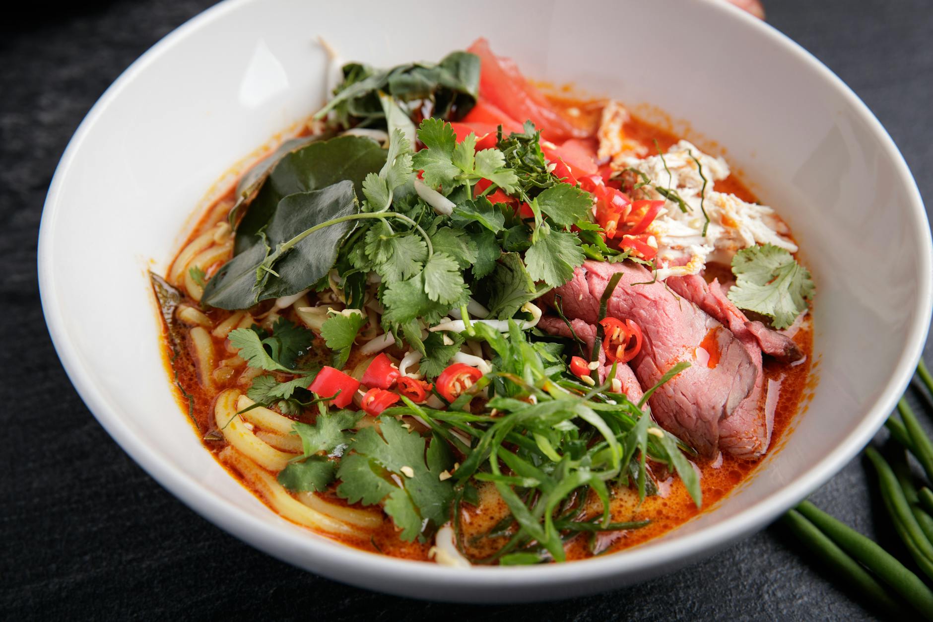 Tajskie czerwone curry z wołowiną na mleku kokosowym – rozgrzewający przepis na zimę Tajskie czerwone curry z wołowiną i makaronem w białej misce
